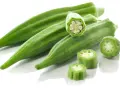 Kilka zielonych strąków okry, w tym przekrojone, ukazujące nasiona. Okra po polsku to pyszny dodatek do dań.