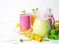 Kolorowe smoothie odchudzające przepisy w dzbanku i szklankach, ozdobione miętą i taśmą mierniczą.