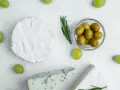 Ser brie, pleśniowy i winogrona otaczają miseczkę z oliwkami. Czy oliwki są lekkostrawne?