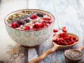 Miseczka smoothie z owocami i nasionami. Nasiona chia, jagody, maliny, pestki dyni i słonecznika. Niski indeks glikemiczny.