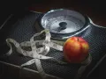 Waga, jabłko i miarka krawiecka symbolizują dietę strażników wagi.