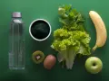 Składniki na japońską dietę wodną: butelka wody, spirulina, kiwi, sałata, seler, banan i jabłko.
