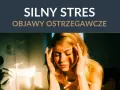 Kobieta z dłońmi na skroniach, wyrażająca silny stres. Objawy przewlekłego stresu mogą być widoczne na twarzy.