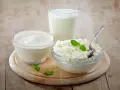 Kefir, jogurt i twaróg na drewnianej desce. Czy kefir jest dobry na odchudzanie? Te produkty to podstawa zdrowej diety.