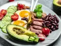 Talerz z jajkami sadzonymi, boczkiem, awokado, fasolą i warzywami. Czy dieta keto jest zdrowa?
