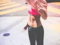 Kobieta z różowymi włosami w sportowym topie i legginsach. Zastanawiasz się, co jeść, żeby przytyć 10 kg?
