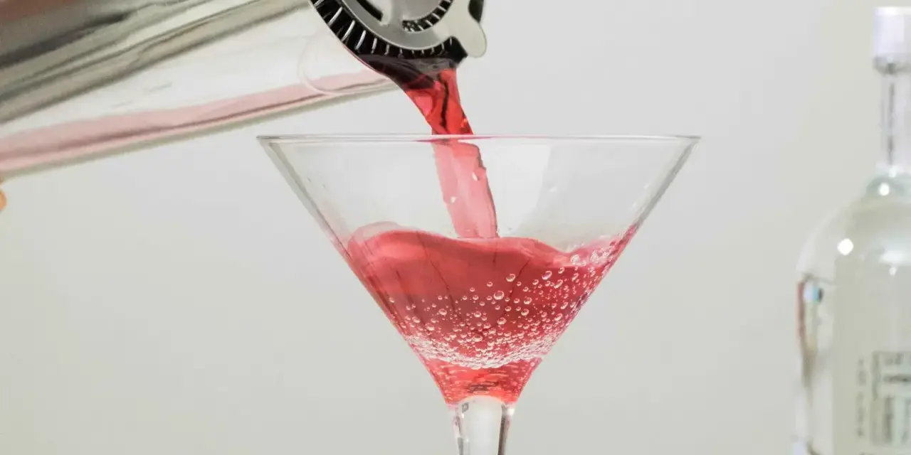 Czerwony drink nalewany do kieliszka, idealny dla tych, którzy zastanawiają się, jaki alkohol ma najmniej kalorii.