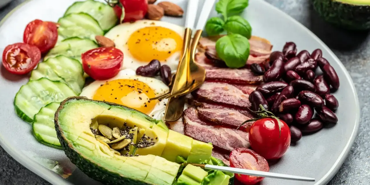 Talerz z jajkami sadzonymi, boczkiem, awokado, fasolą i warzywami. Czy dieta keto jest zdrowa?