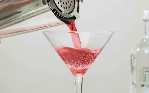 Czerwony drink nalewany do kieliszka, idealny dla tych, którzy zastanawiają się, jaki alkohol ma najmniej kalorii.