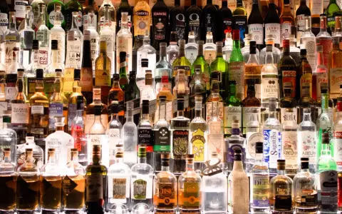 Wiele butelek alkoholu na półce. Czy istnieje alkohol bez kalorii?
