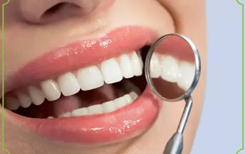 Biała dieta po wybielaniu zębów? Uśmiech jak z reklamy, lśniące zęby odbijają się w lusterku dentystycznym.