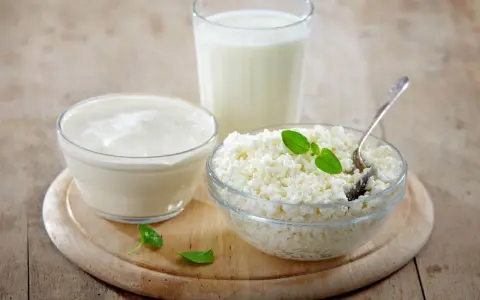 Kefir, jogurt i twaróg na drewnianej desce. Czy kefir jest dobry na odchudzanie? Te produkty to podstawa zdrowej diety.