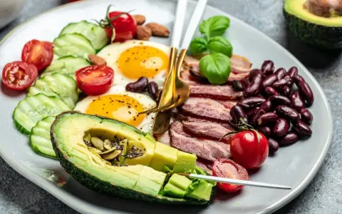 Talerz z jajkami sadzonymi, boczkiem, awokado, fasolą i warzywami. Czy dieta keto jest zdrowa?