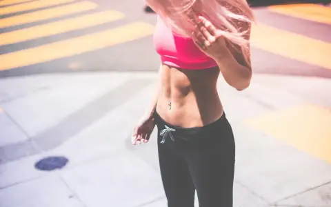 Kobieta z różowymi włosami w sportowym topie i legginsach. Zastanawiasz się, co jeść, żeby przytyć 10 kg?
