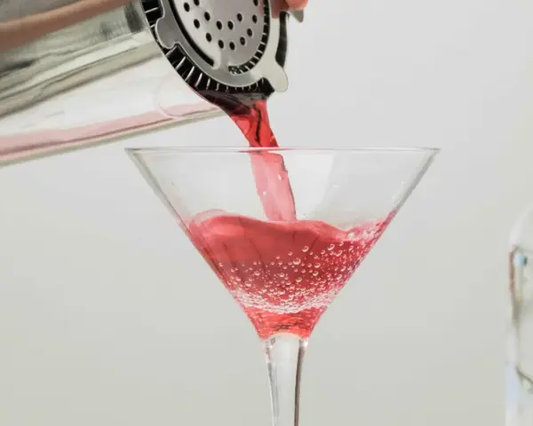Czerwony drink nalewany do kieliszka, idealny dla tych, którzy zastanawiają się, jaki alkohol ma najmniej kalorii.