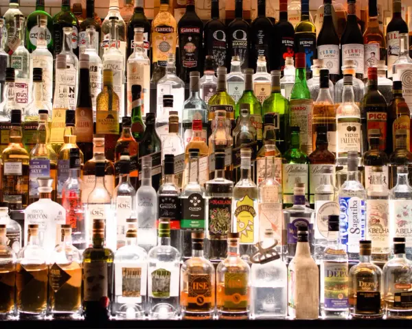 Wiele butelek alkoholu na półce. Czy istnieje alkohol bez kalorii?