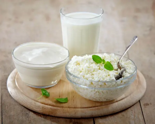 Kefir, jogurt i twaróg na drewnianej desce. Czy kefir jest dobry na odchudzanie? Te produkty to podstawa zdrowej diety.