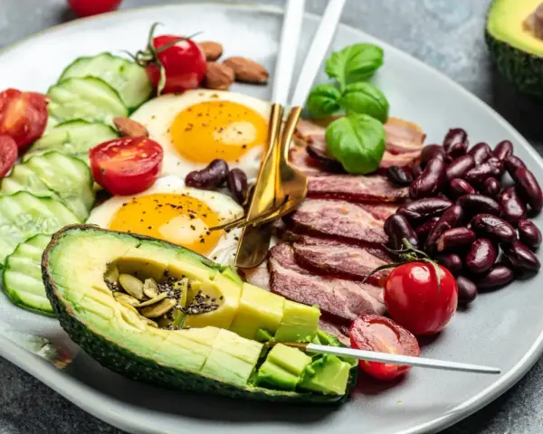Talerz z jajkami sadzonymi, boczkiem, awokado, fasolą i warzywami. Czy dieta keto jest zdrowa?