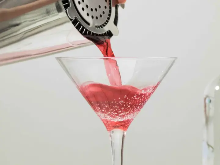 Czerwony drink nalewany do kieliszka, idealny dla tych, którzy zastanawiają się, jaki alkohol ma najmniej kalorii.