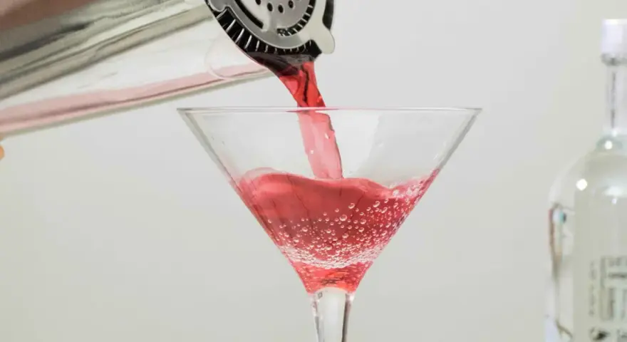 Czerwony drink nalewany do kieliszka, idealny dla tych, którzy zastanawiają się, jaki alkohol ma najmniej kalorii.