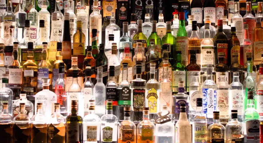 Wiele butelek alkoholu na półce. Czy istnieje alkohol bez kalorii?