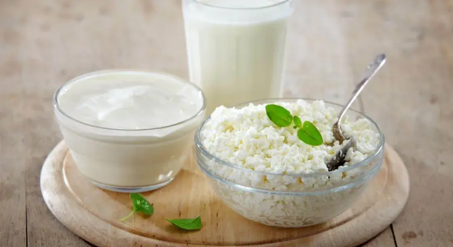 Kefir, jogurt i twaróg na drewnianej desce. Czy kefir jest dobry na odchudzanie? Te produkty to podstawa zdrowej diety.