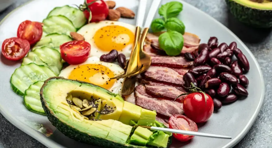 Talerz z jajkami sadzonymi, boczkiem, awokado, fasolą i warzywami. Czy dieta keto jest zdrowa?