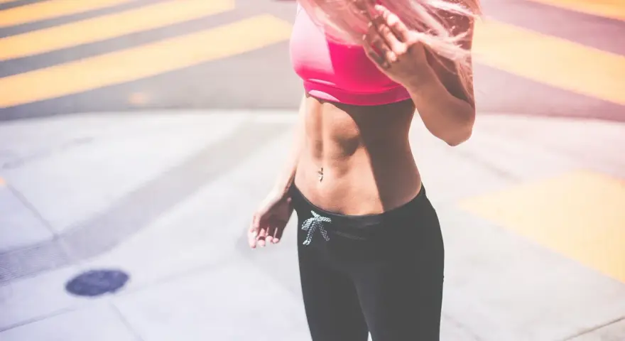 Kobieta z różowymi włosami w sportowym topie i legginsach. Zastanawiasz się, co jeść, żeby przytyć 10 kg?