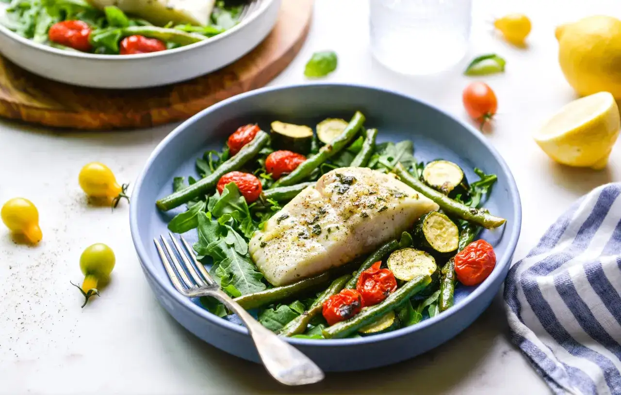 Ryba z warzywami na talerzu, idealna na dietę low carb. Smaczne i zdrowe danie.