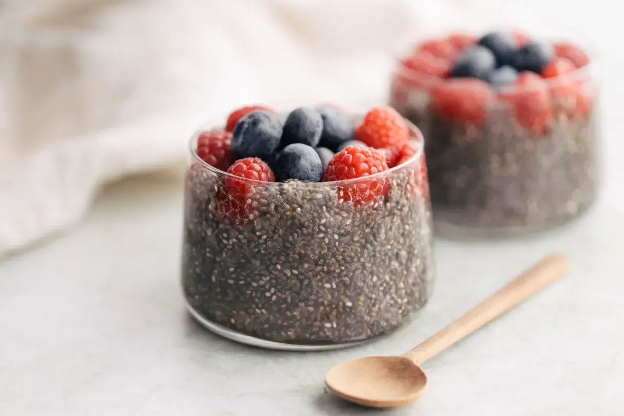 Pudding chia z malinami i borówkami. Nasiona chia mają niski indeks glikemiczny, co czyni je idealnym wyborem na zdrowy deser.