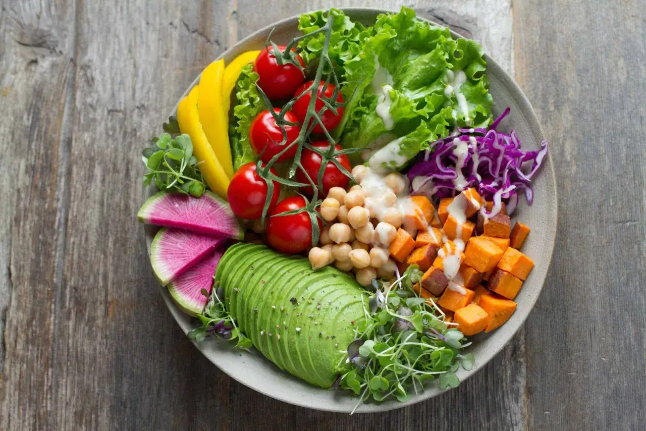 Kolorowa sałatka z awokado, ciecierzycą, batatami i warzywami. Idealna na zdrową dietę bez mięsa.