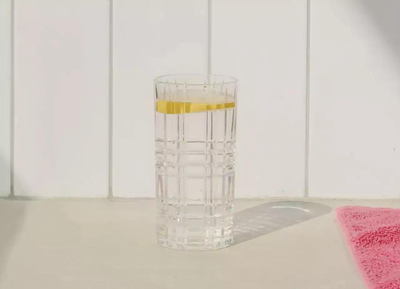 Szklanka z wodą i plasterkiem cytryny, idealna na początek dnia, wspierając japońską dietę wodną.